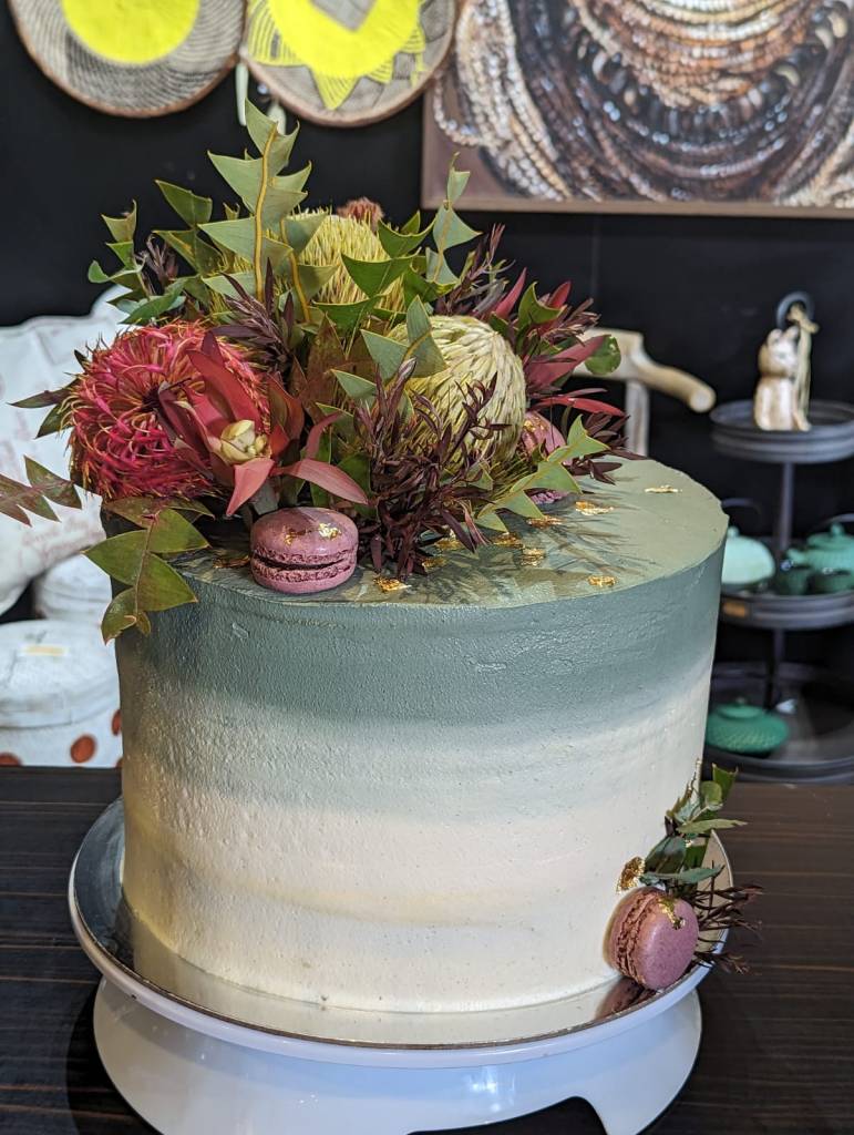 A three layer wedding cake with native flowers serving as an example of The Silva Spoon Custom Cake